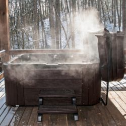 Steaming,Hot,Tub,On,Deck,With,Snow,In,Background